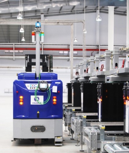 Robot tự vận hành trong Nhà máy sữa Việt Nam đang tự đi tìm bình ăc-quy được nạp đầy điện để tư thay cho mình khi hết năng lượng.